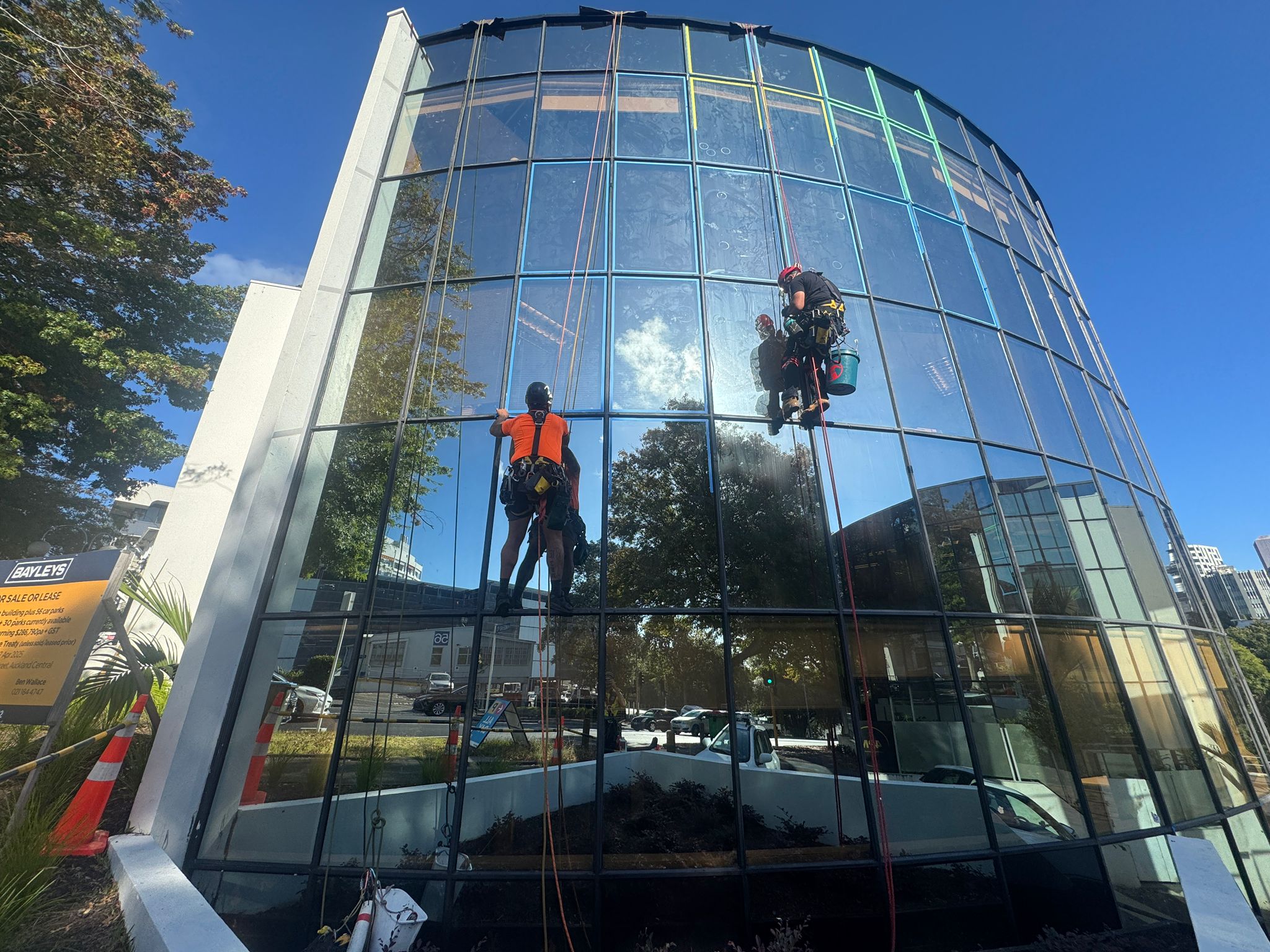 Rope access team sealing windows on a glass facade