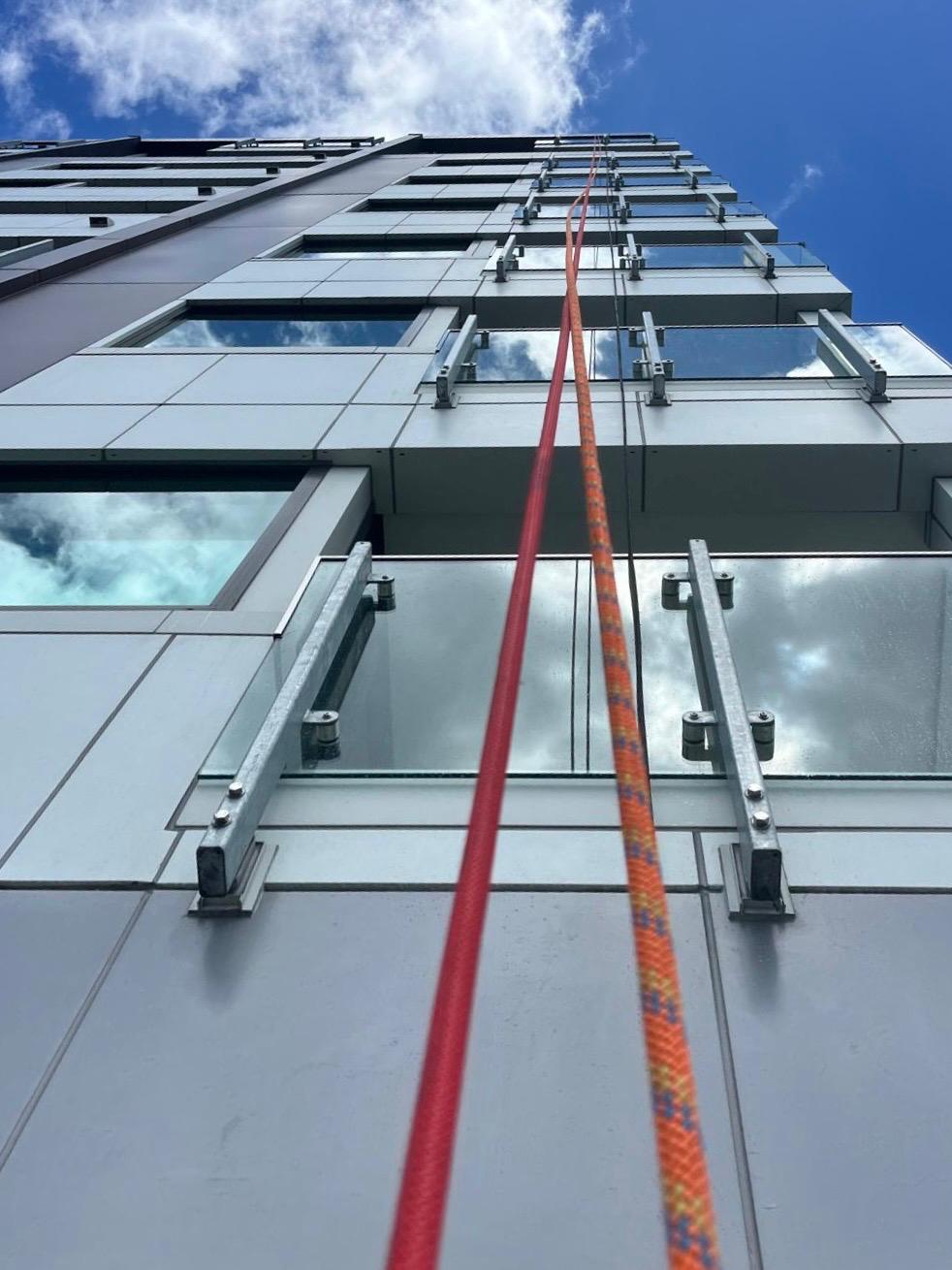 Rope access lines running up a commercial facade